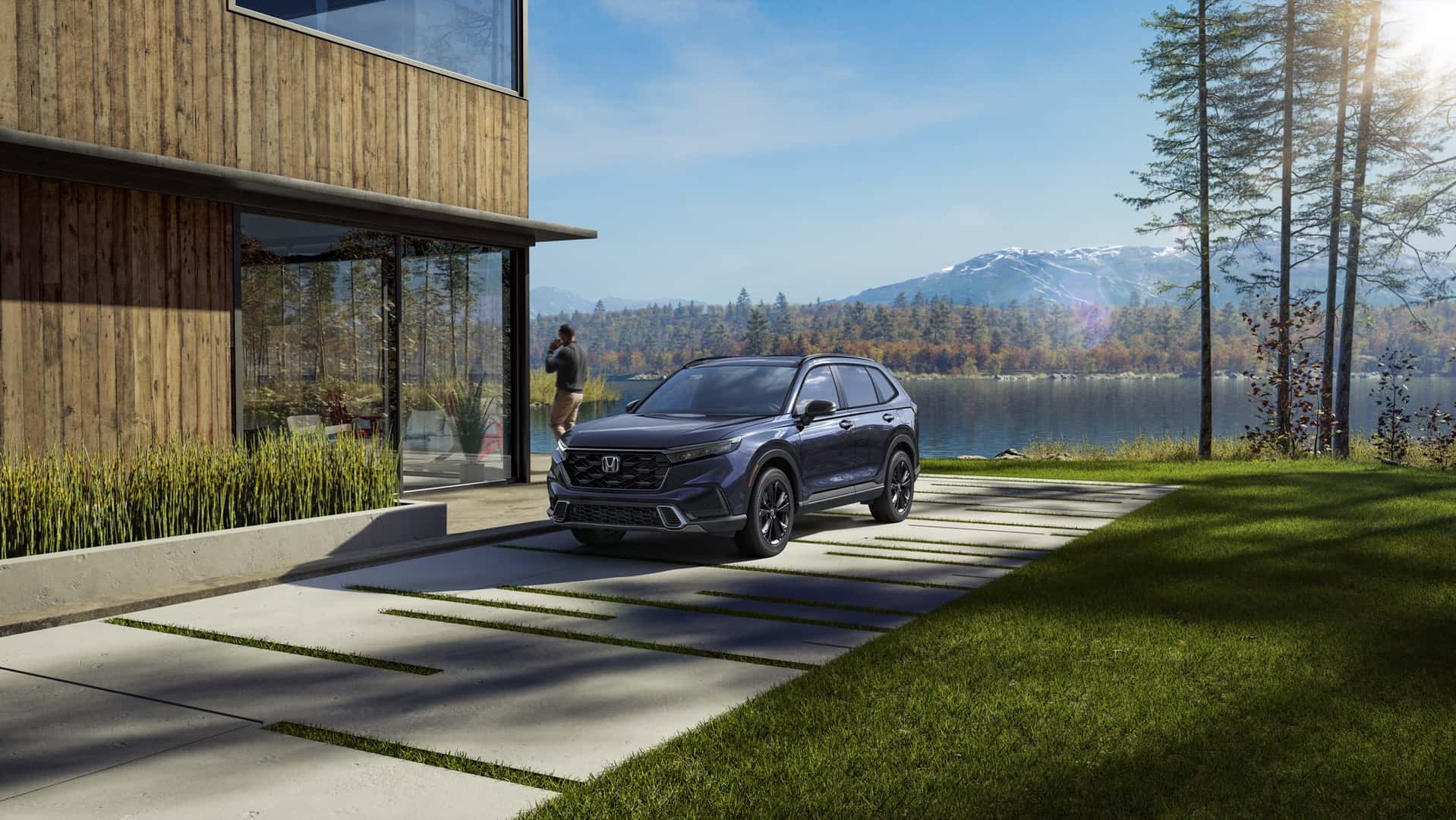 Blue Honda CR-V Sport Touring Hybrid outside a lakeside home