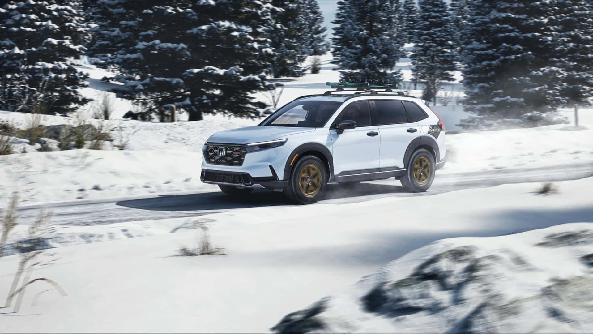 White Honda CR-V TrailSport Hybrid driving on a snowy road