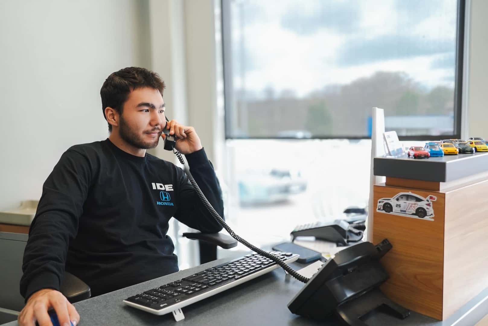 An Ide Honda team member on the phone at the service counter