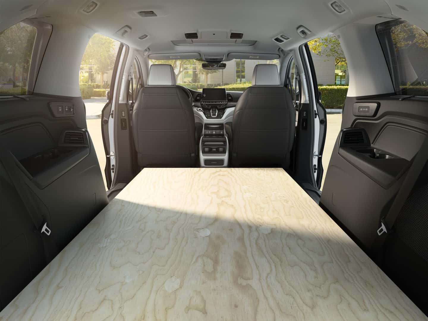 Honda Odyssey cargo area carrying a sheet of plywood with the second-row seats removed and third row folded