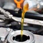 Pouring new oil into vehicle during an oil change