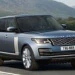 Blue Range Rover driving down a scenic road