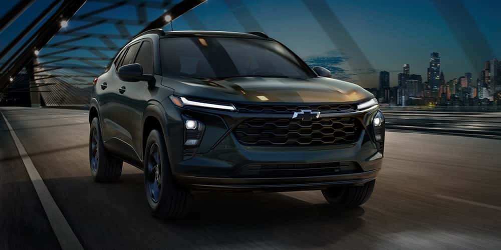 A dark-colored Chevrolet Trax driving over a bridge