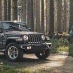 Jeep Wrangler Parked in Forest with Couple Hiking