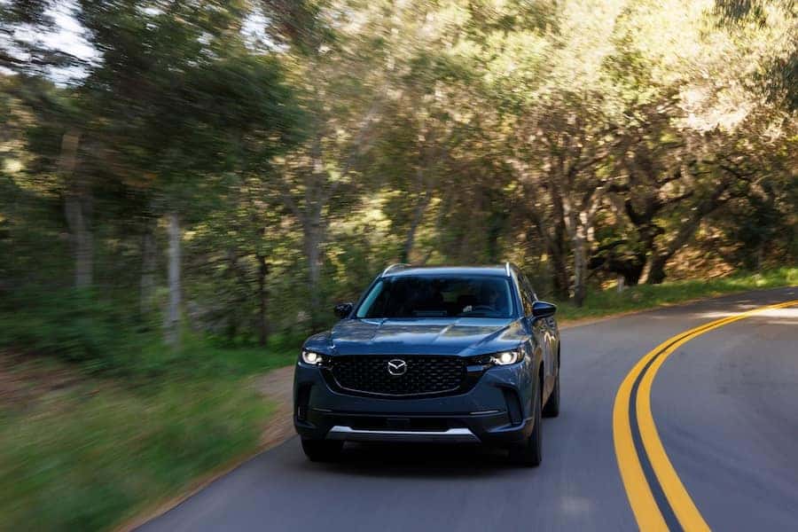 Mazda CX-50 SUV driving on a scenic winding road