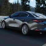 Mazda3 sedan driving on a mountain road during winter