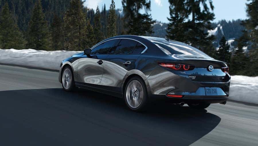 Mazda3 sedan driving on a mountain road during winter