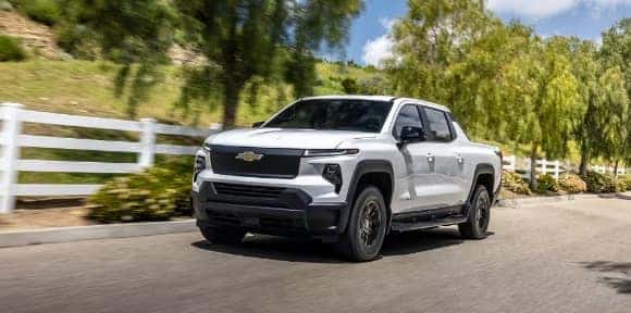 Promotional graphic highlighting Chevrolet trucks and SUVs, including EV options and protection plan coverage