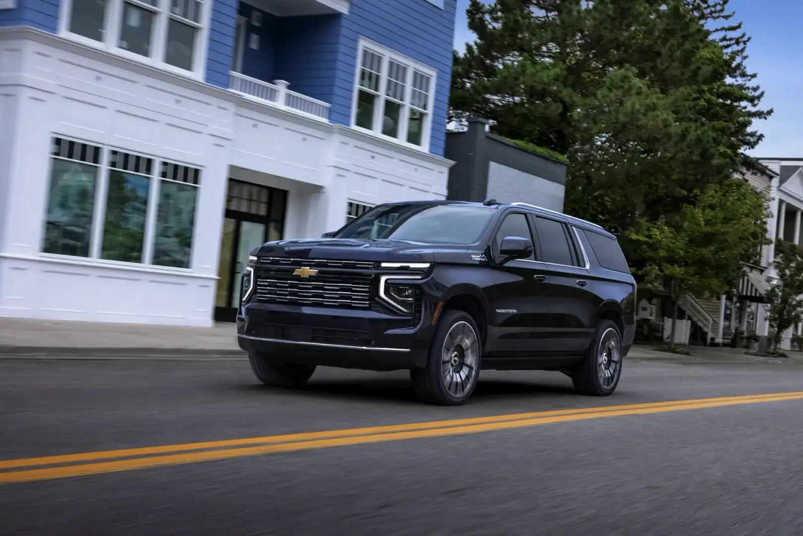 Chevrolet Suburban High Country driving in front of a house