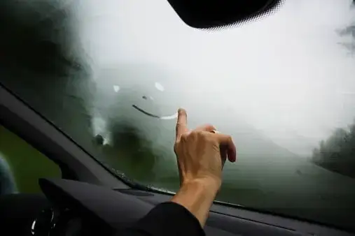 foggy car window with someone drawing a smily face
