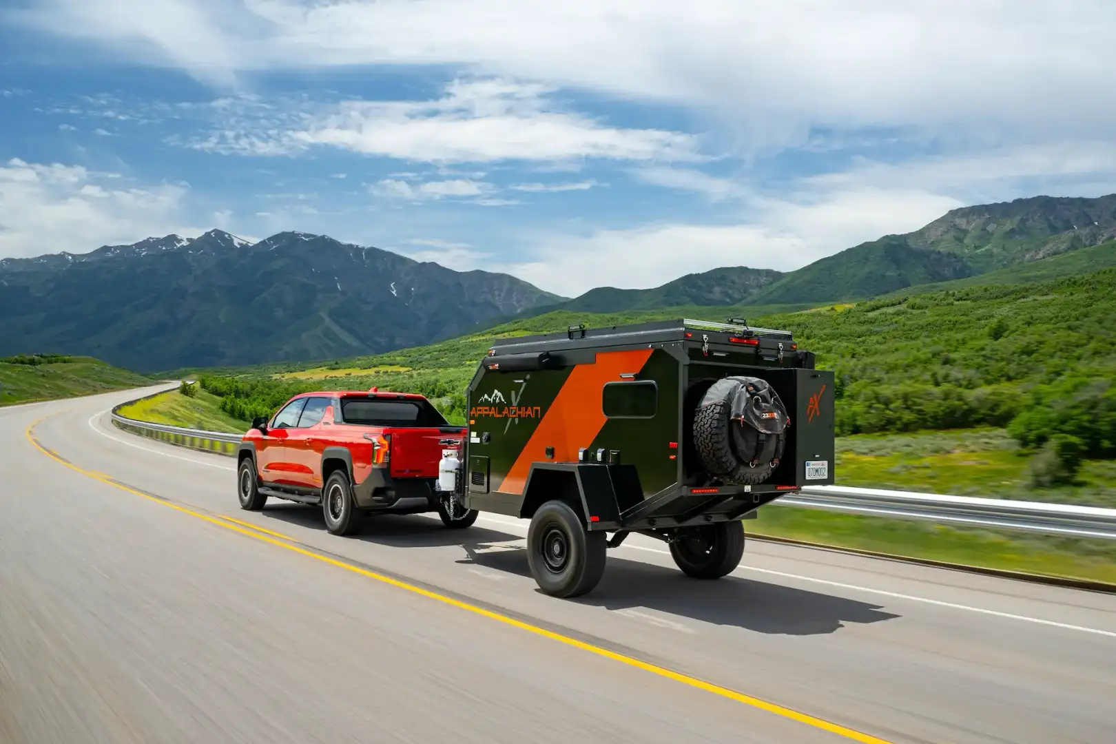 Chevrolet Silverado EV Trail Boss towing a camper trailer into the mountains