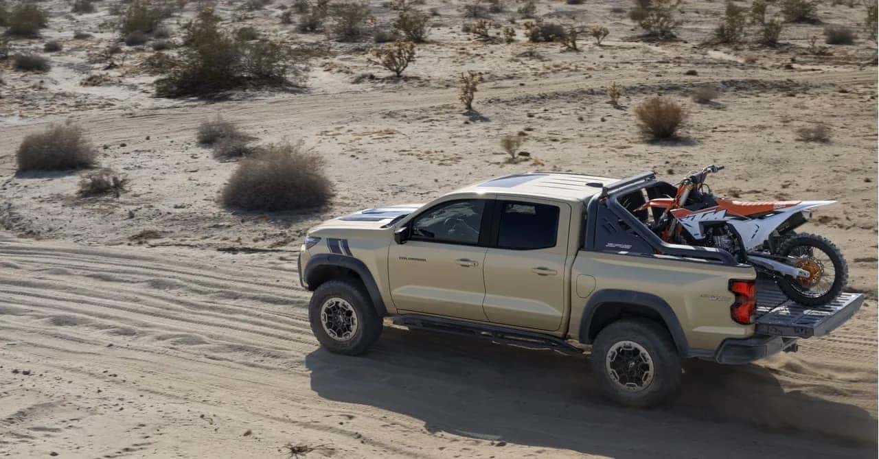 The Powerful Chevrolet Colorado ZR2 Driving In The Desert, With A Mountain Bike Secured In Its Truck Bed