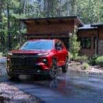 The Robust And Family Friendly Chevrolet Traverse, Parked Outside A Cozy Home In The Middle Of The Woods