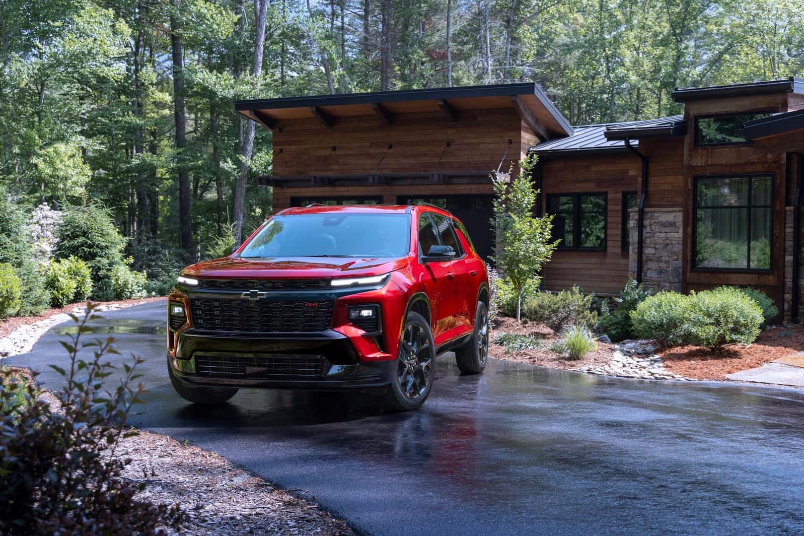 The Robust And Family Friendly Chevrolet Traverse, Parked Outside A Cozy Home In The Middle Of The Woods