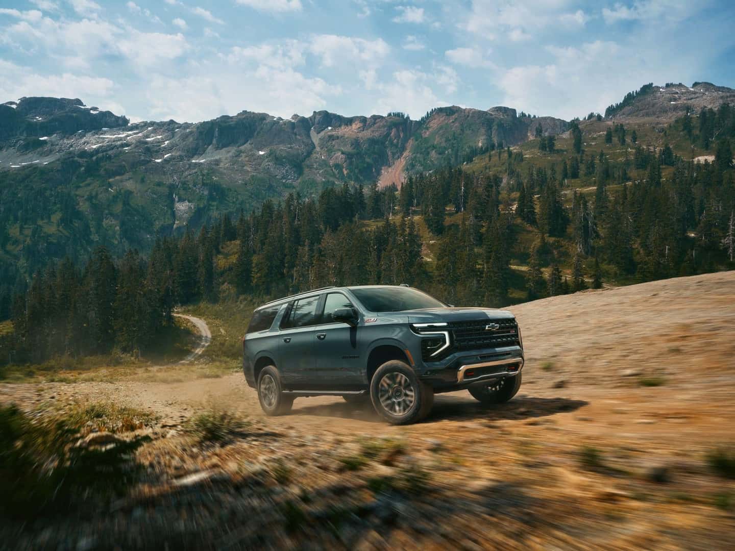 The Spacious And Family Friendly 2026 Chevrolet Suburban Kicking Up Dust As It Races On Dirt Roads Near A Vast Forests