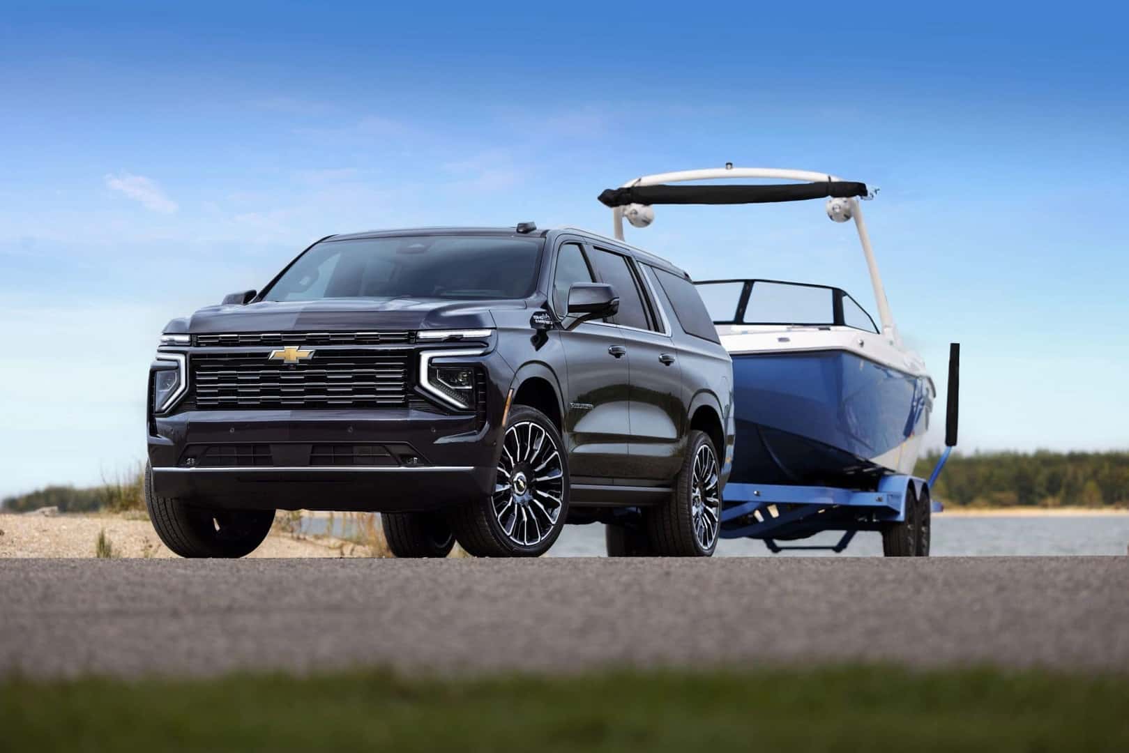 The Sturdy And Strong 2026 Chevrolet Suburban High Country Towing A Boat For The Family Vacation On Water