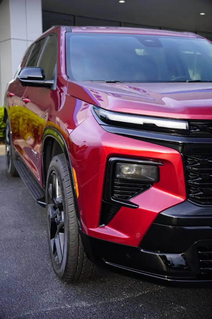Close-up front view of a red Chevrolet Traverse parked on the lot at McFarland Chevrolet, showcasing the bold styling of Chevy's full-size family SUV