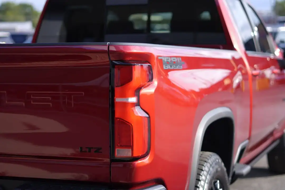 Rear corner view of a red Chevy Silverado LT Trail Boss truck bed, showing the taillight, LTZ badging, and Trail Boss decal
