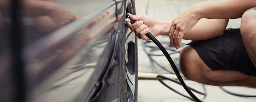 Driver checking tire pressure 