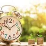 A clock next to three stacks of coins