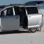 A parked minivan in a sandy field
