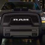 Front of black 2019 RAM 1500 in alley at night with headlights on