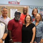 An image displaying Taylor Hood and the members of LEI in a classroom with four