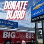 Big Red Bus Parked In Front of Preston Hood Chevrolet
