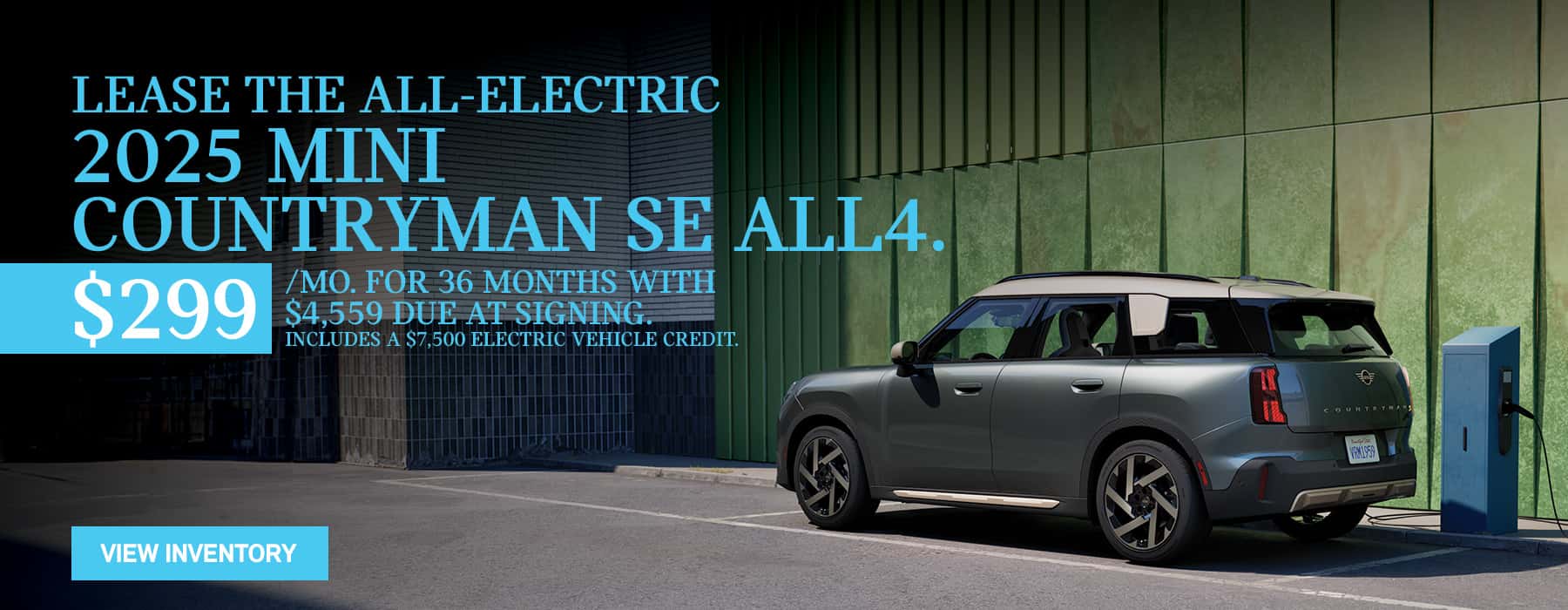 MINI Countryman SE charging in front of green wall.