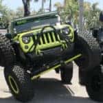 3 Jeep Wranglers flexing on each other in dealership parking lot