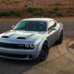 A blue 2018 Dodge Challenger, silver 2018 Dodge Challenger, and red 2018 Dodge Challenger lined up in the desert