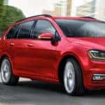 Red 2019 Volkswagen Golf SportWagen rounding street corner