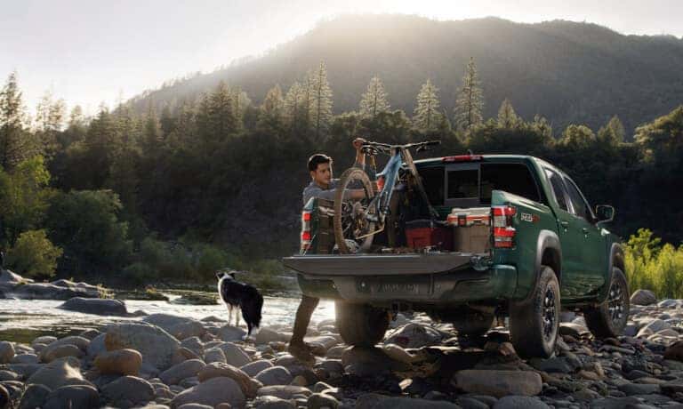 2024 Nissan Frontier Exterior With Driver Getting Bike From Bed