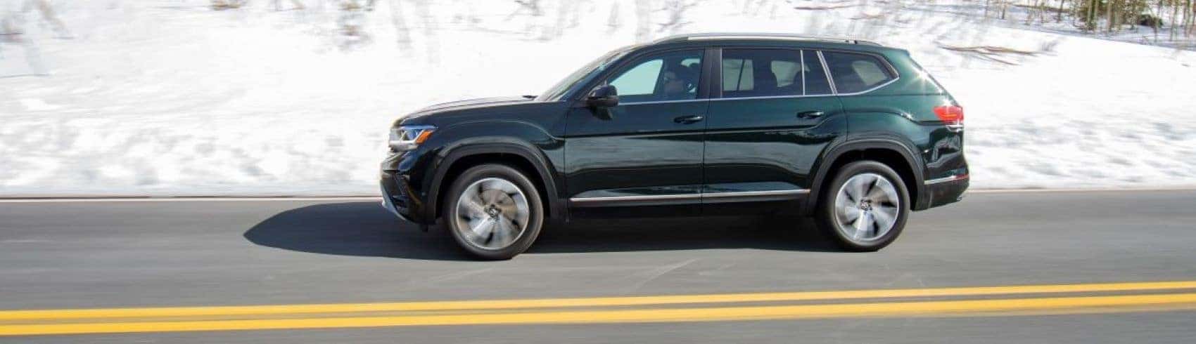 2022 VW Atlas in Green Metallic side profile driving on road with white snow behind