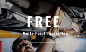 Free multi-point inspection written on top of a photograph of a tech looking underneath a car