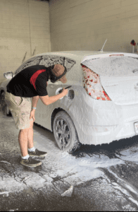 a photograph of Zach from Toyota of Corvallis is cleaning a vehicle in our detail department