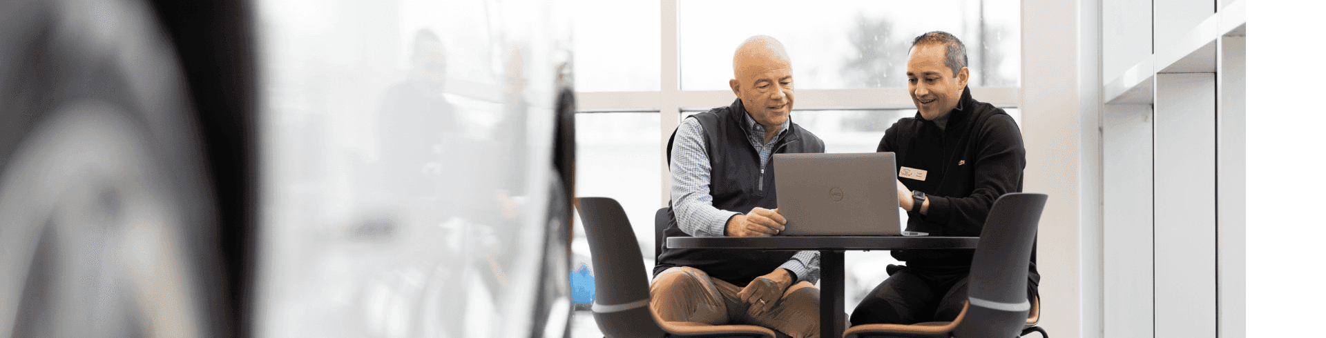 customer talking with sales person next to a laptop