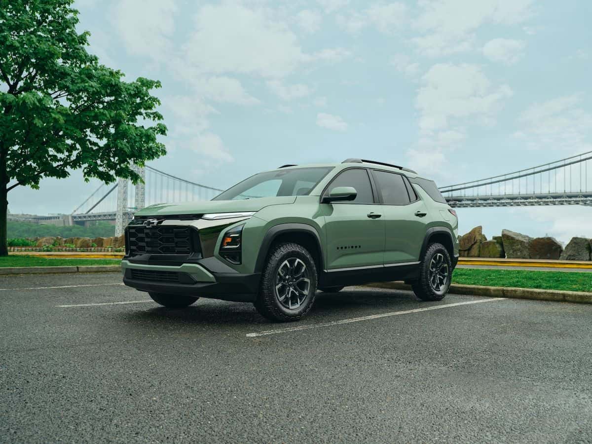 Green Chevrolet Equinox compact SUV parked beside a suspension bridge